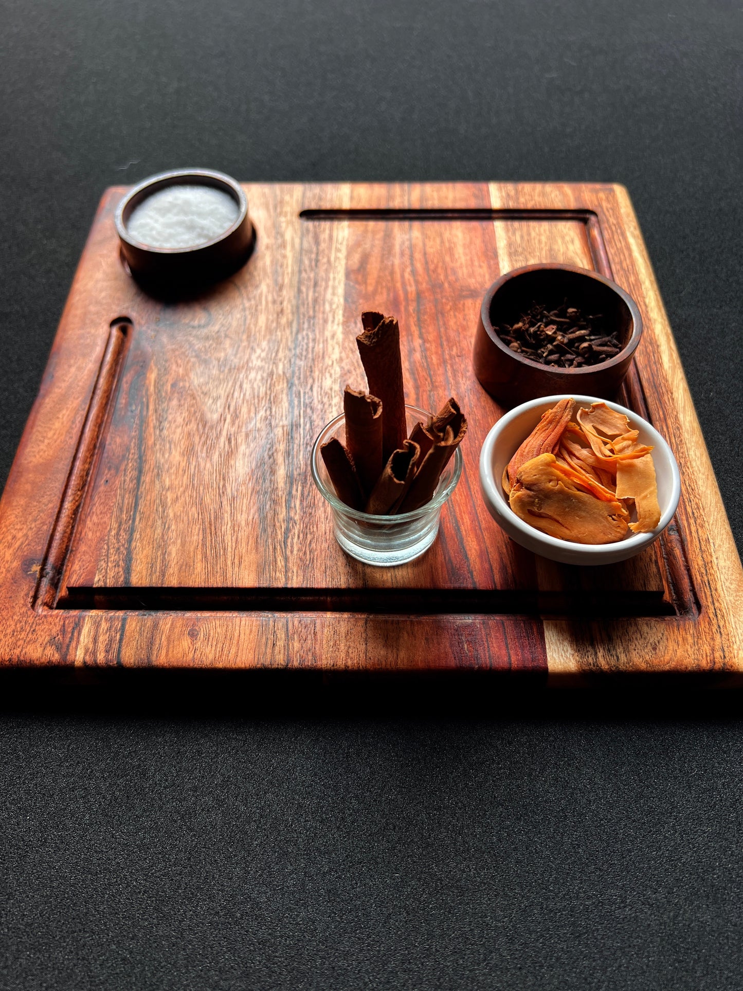 Close-up of the acacia wood grain on the square charcuterie board with a natural finish.
