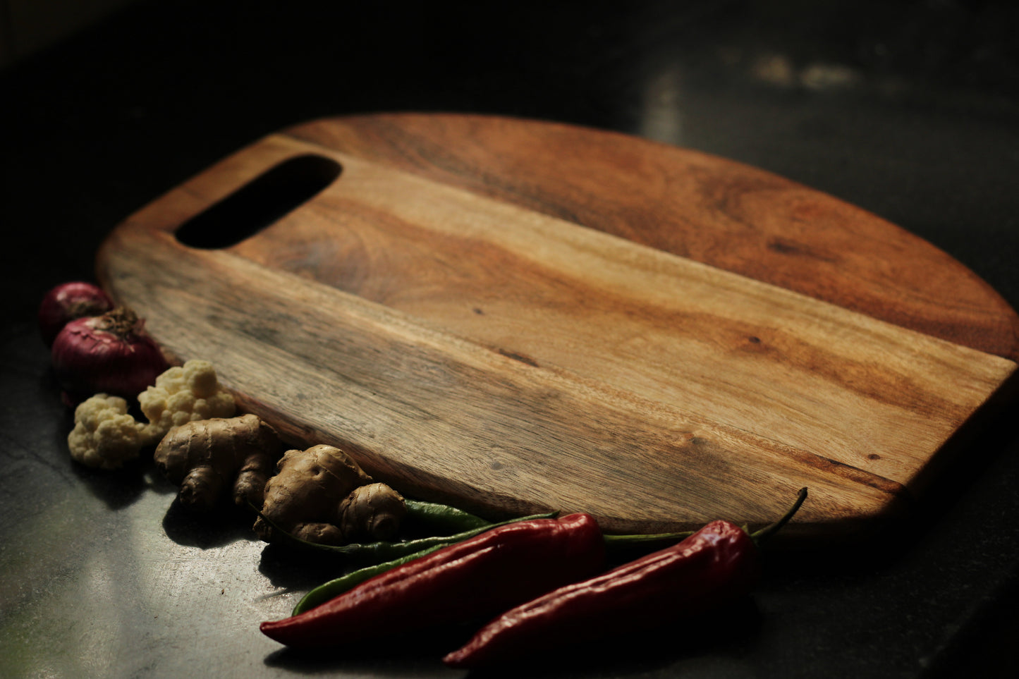 Reversible cutting board displayed with food on both sides, highlighting its dual functionality.
