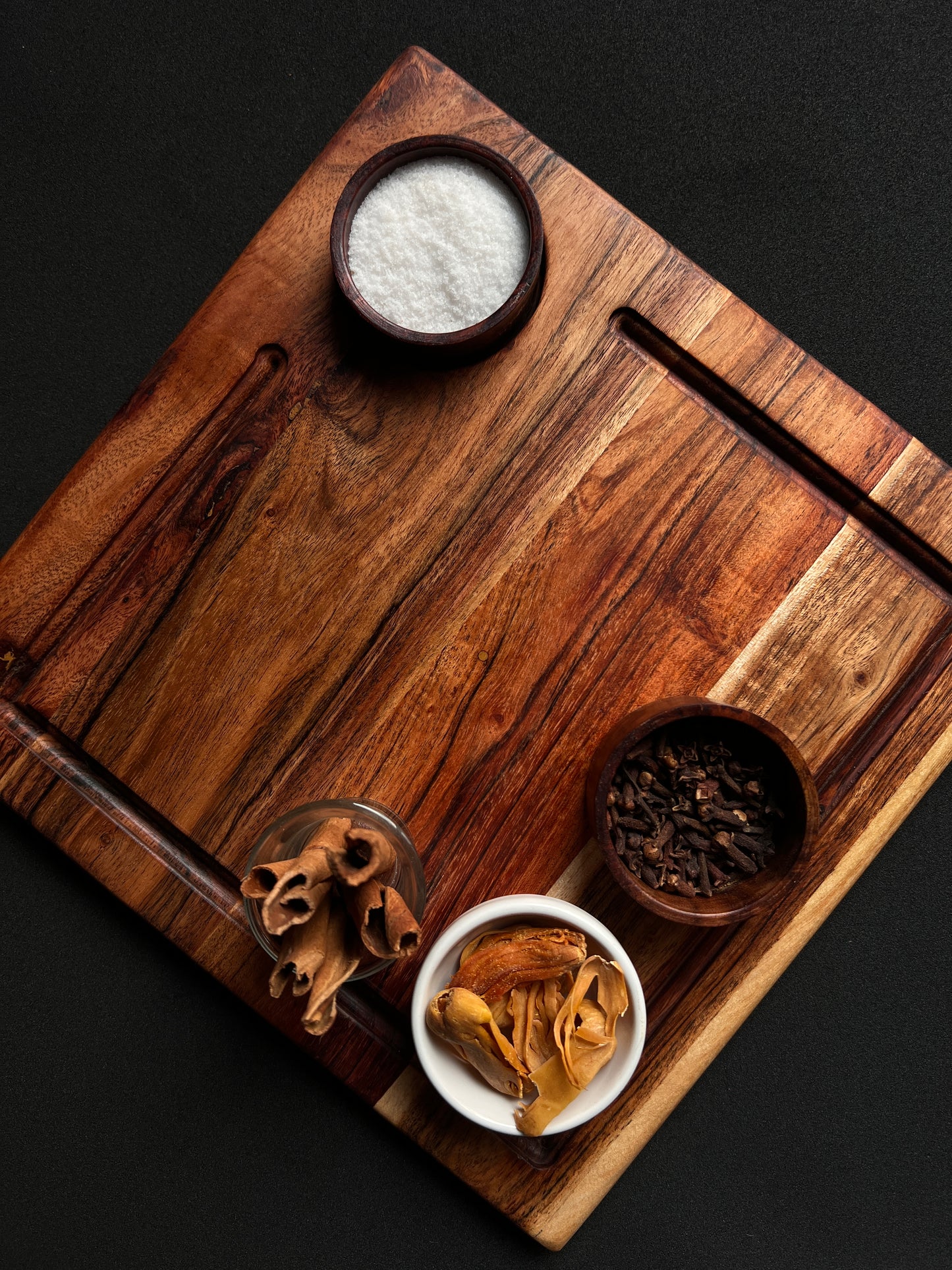 Cheese platter styled with sliced meats and nuts, placed on a dining table.