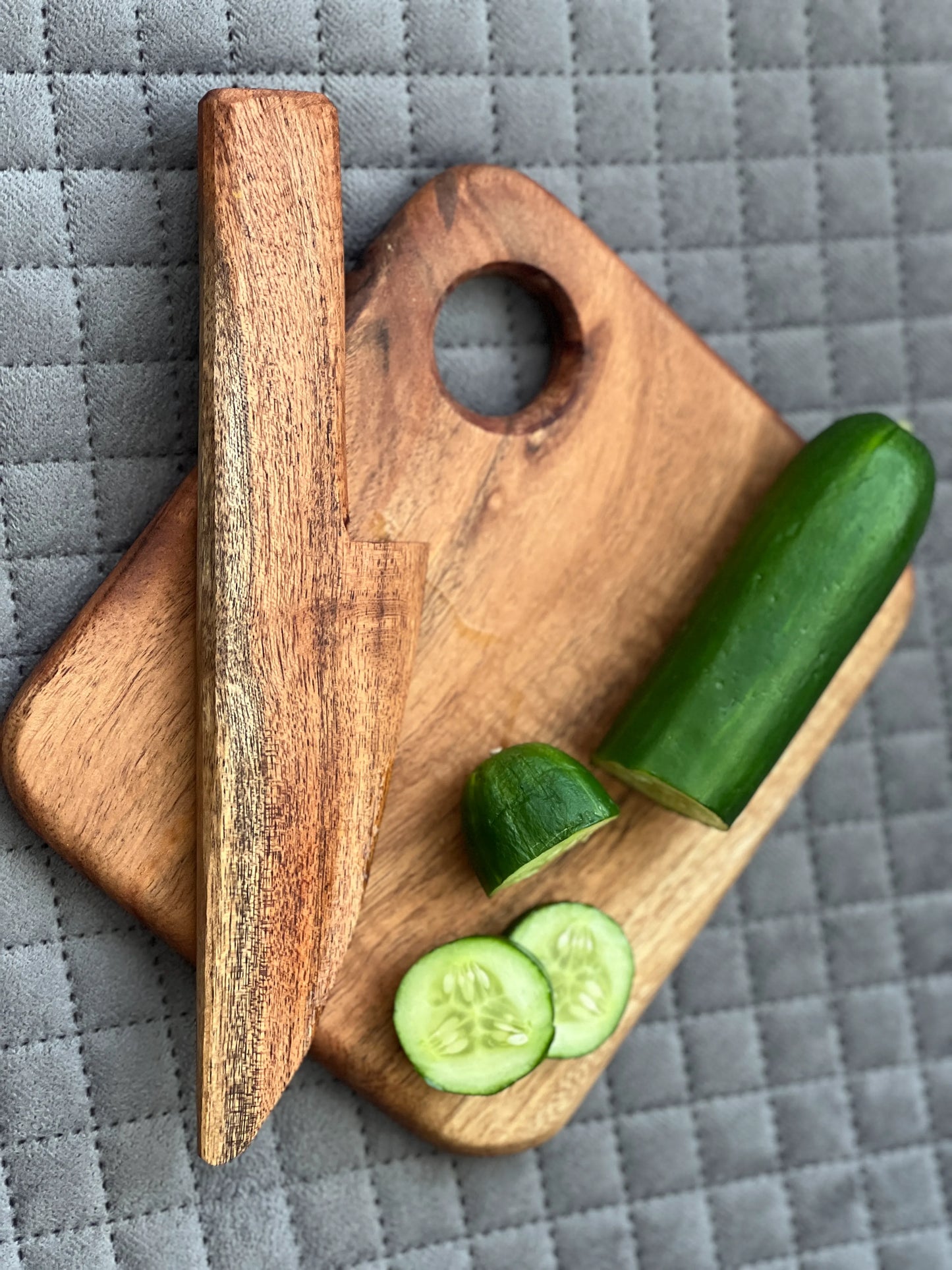 Close-up of smooth wooden knife and food-safe acacia board with rounded edges for safety.