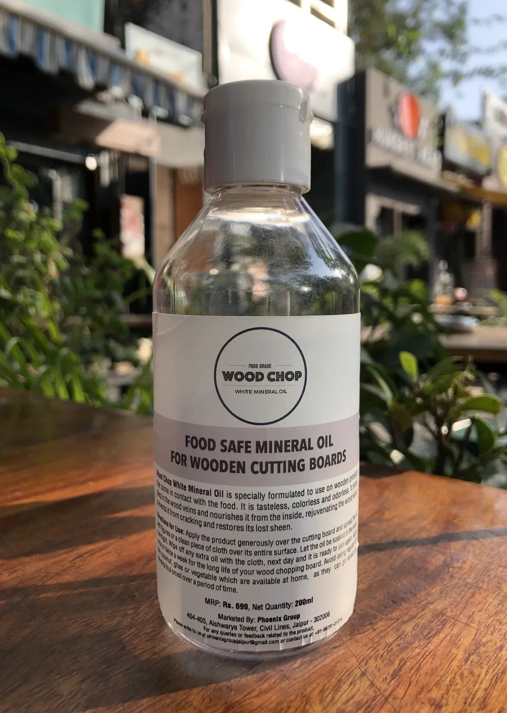 Bottle of mineral oil styled with cutting boards and kitchen towels in a natural setting.