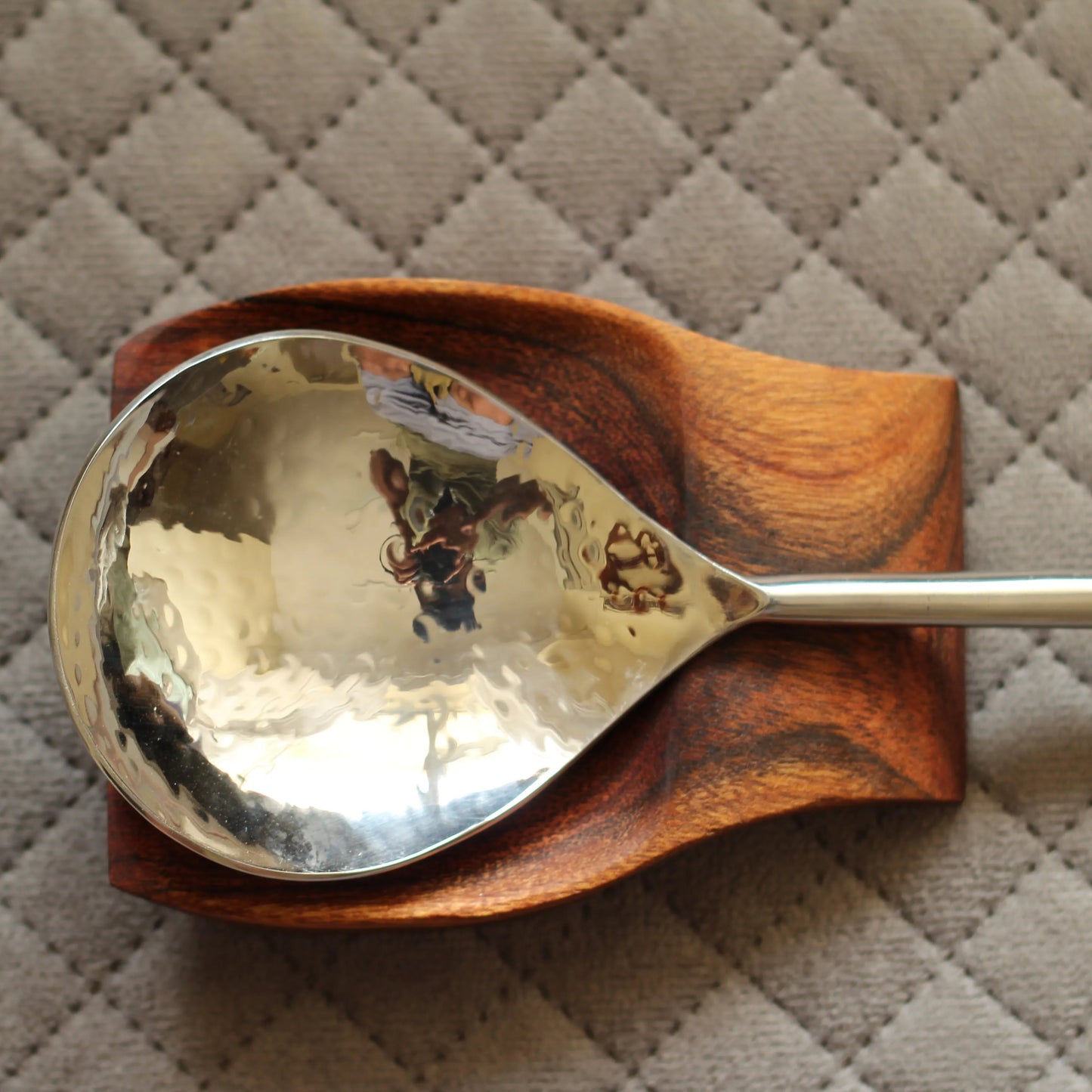 Flat lay of the wooden spoon rest next to various utensils, showing its natural aesthetic and functionality.