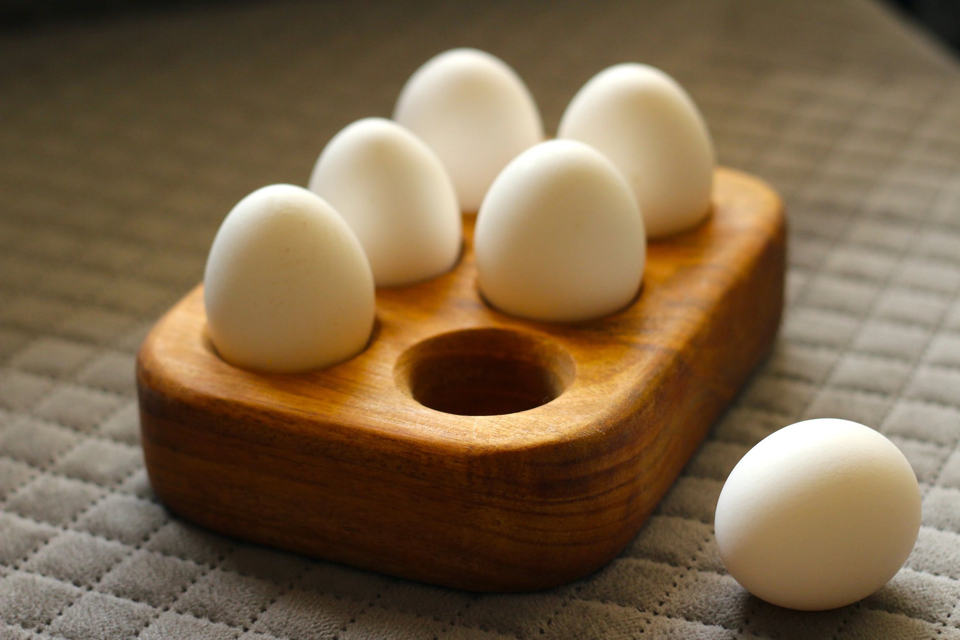 Empty egg tray showing six perfectly carved compartments with a natural matte finish.