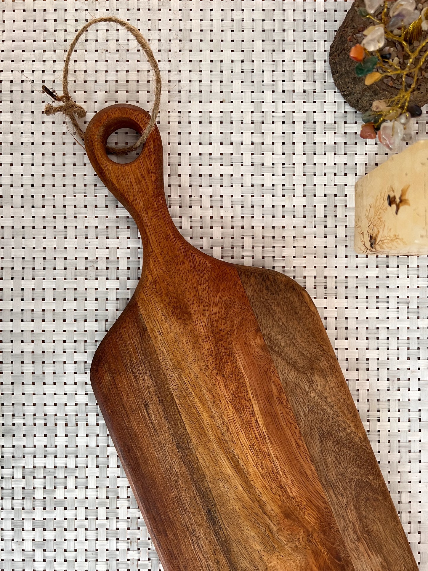 Top view of a 23x6 inch mango wood platter with natural grain finish on a wooden table.