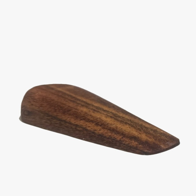 Lifestyle image showing the wooden door wedge holding a heavy door open in a cozy home setting.