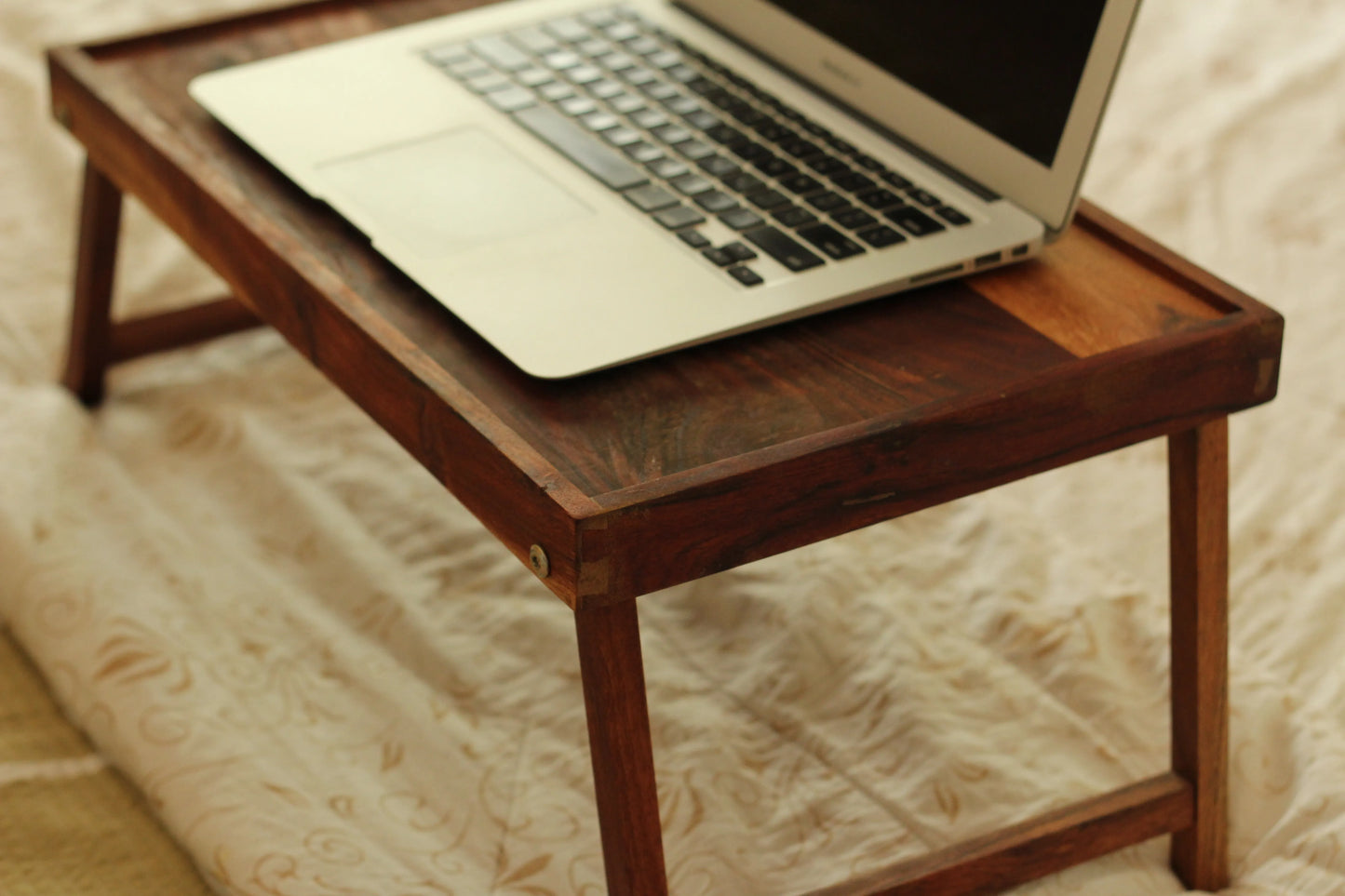 Side view of the laptop desk showing foldable legs and sturdy construction.