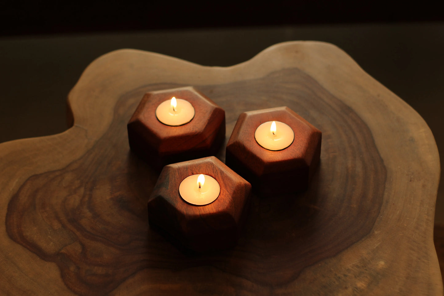 Side profile of all three wooden candle holders stacked to highlight their thickness and polish.
