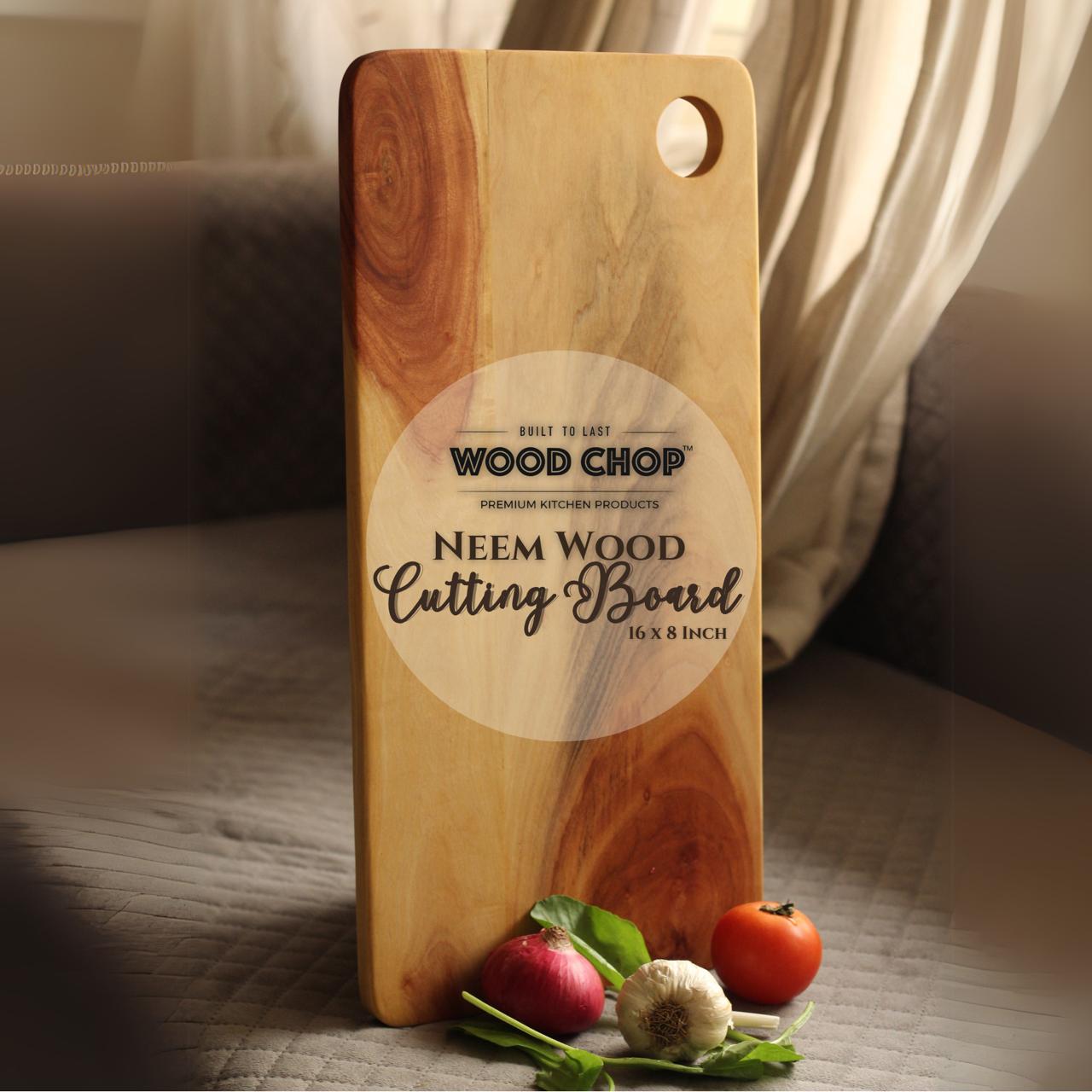 Top view of neem wood cutting board on kitchen counter, showing natural wood grain and rectangular shape.