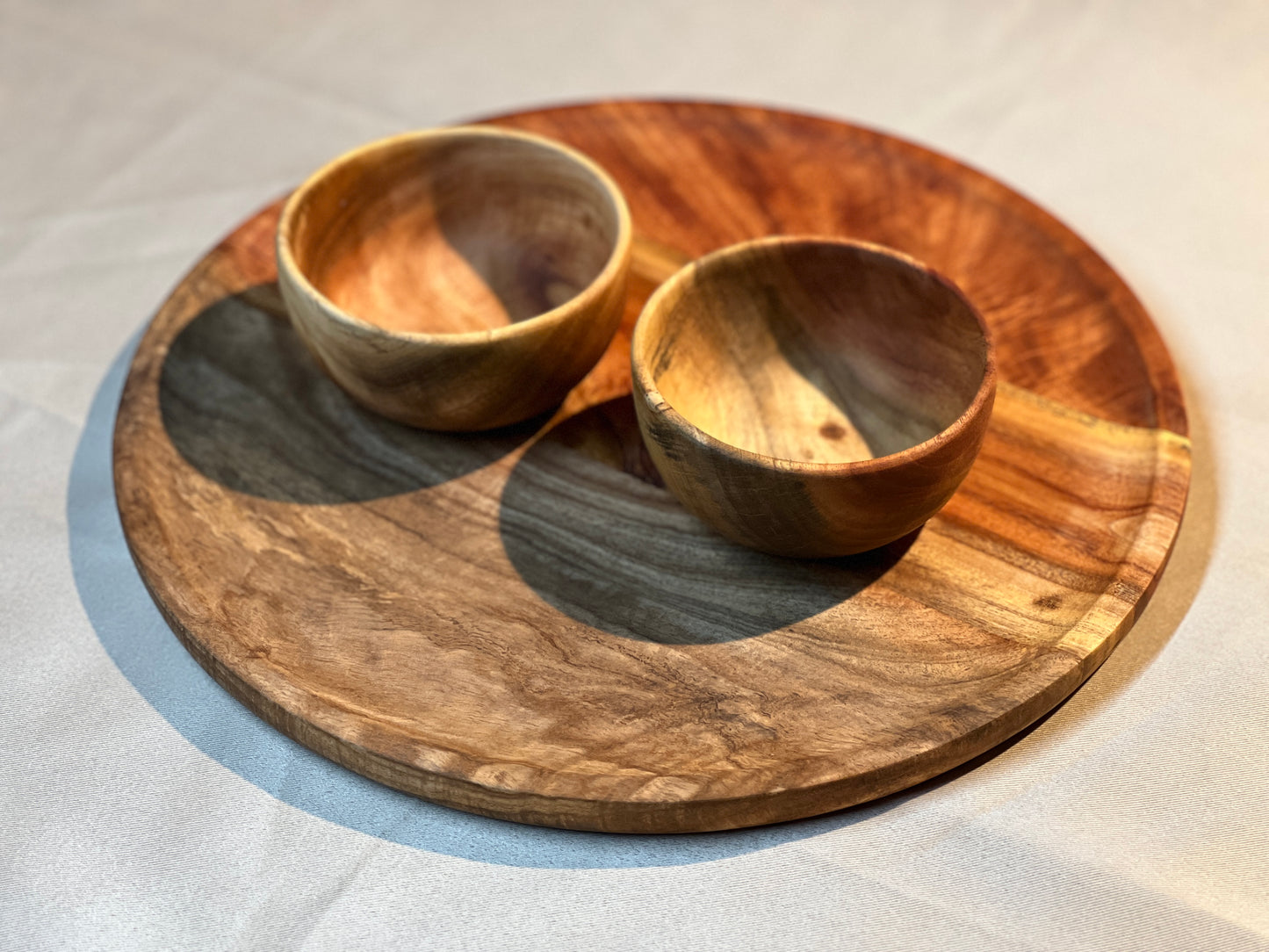 Top view of the neem wood plate with two small bowls placed symmetrically, showcasing natural finish and elegant design.