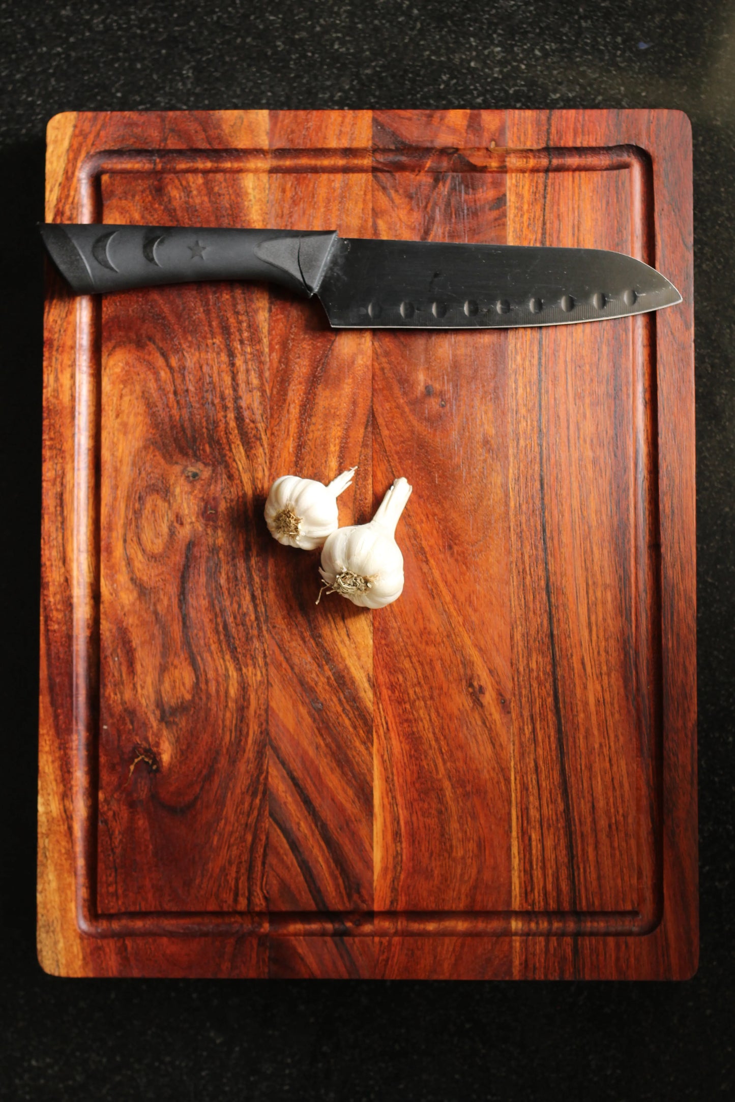 Board placed on a countertop with chopped meat and herbs, highlighting its heavy-duty design.