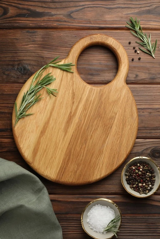 Top view of the round acacia wood chopping board placed on a kitchen counter with vegetables
