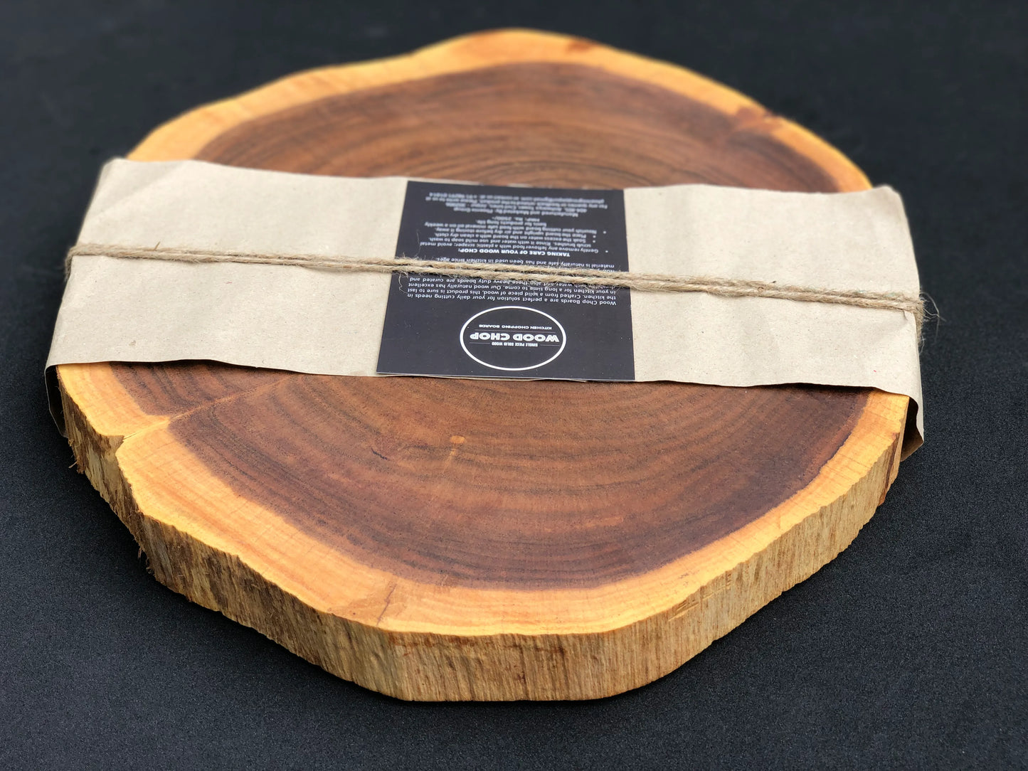 Close-up of rich Sheesham wood grain pattern on a round cutting surface.