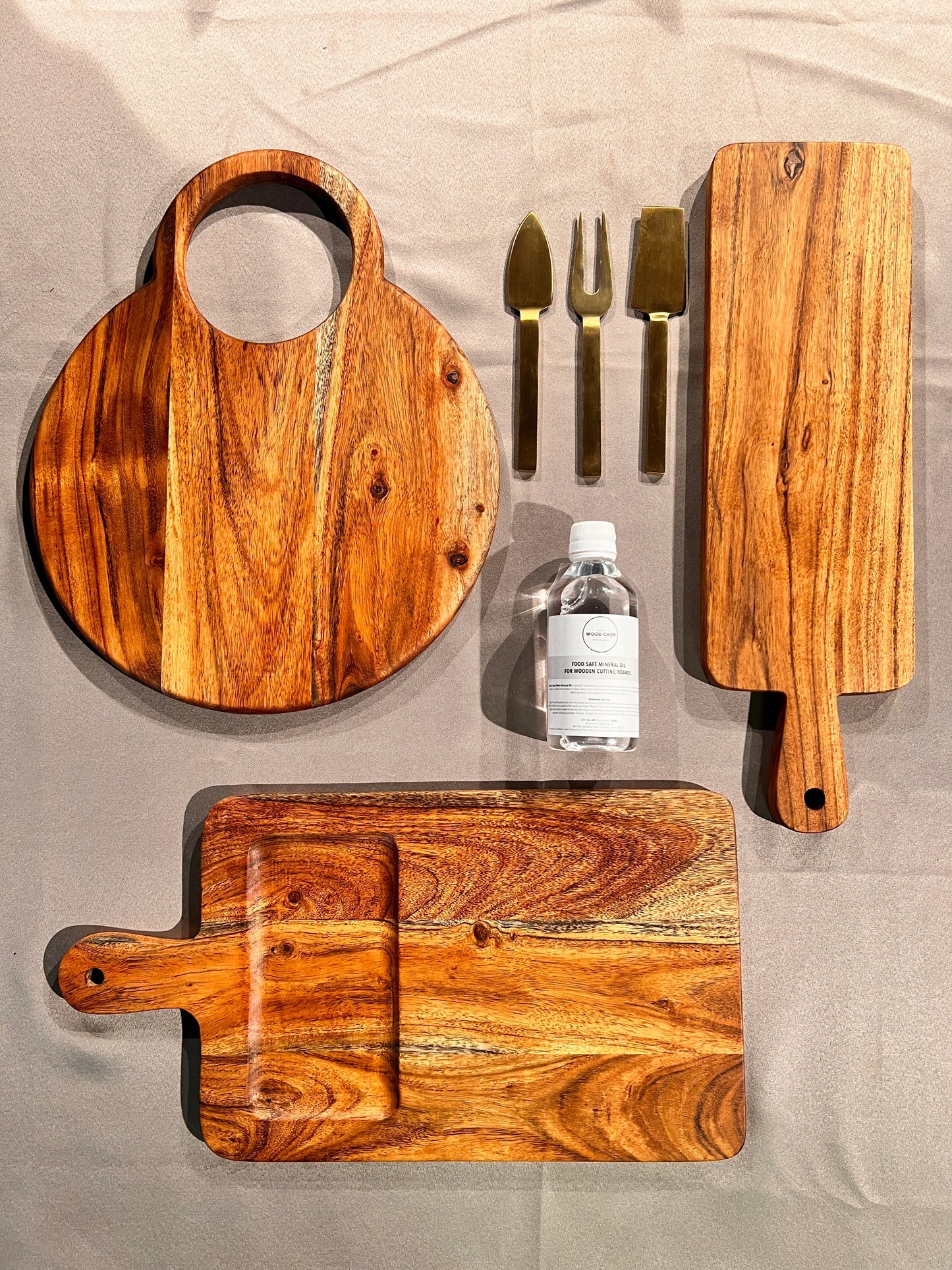 Flat lay of the unpacked set including a serving platter, spoon rest, and coasters arranged on a dining table.