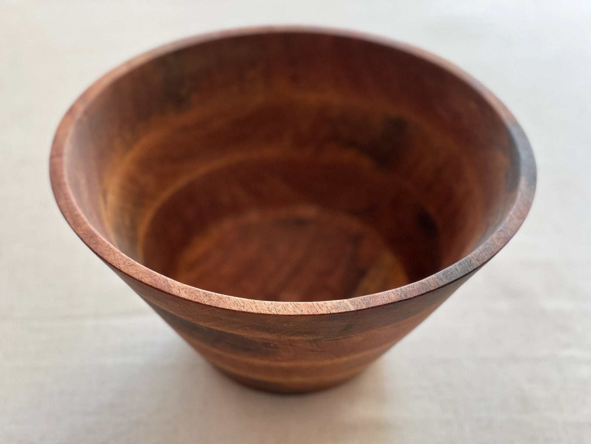 Close-up of the natural mango wood grain and hand-finished surface of the bowl.