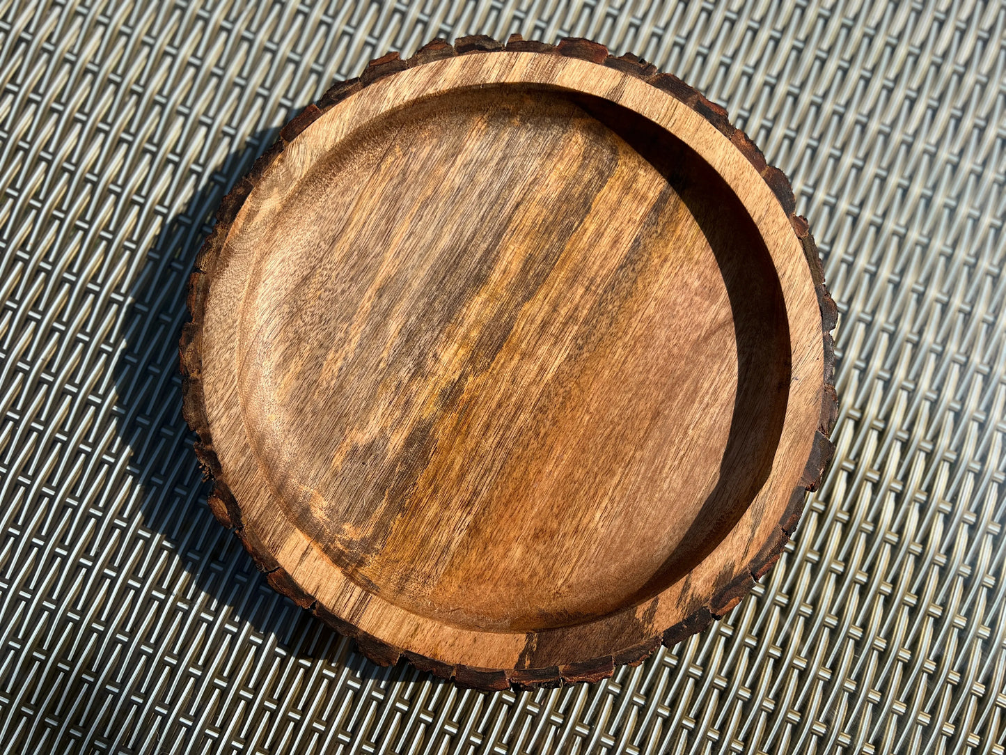 Close-up of rich mango wood grain with a deep, smooth dark finish.