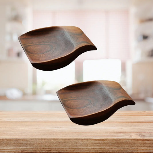 Top view of two acacia wood spoon rests placed side by side on a kitchen counter.

