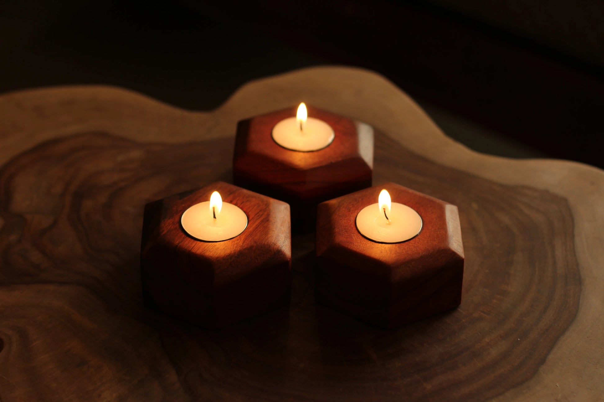  Top view of three acacia wood tea light candle holders arranged neatly on a table.