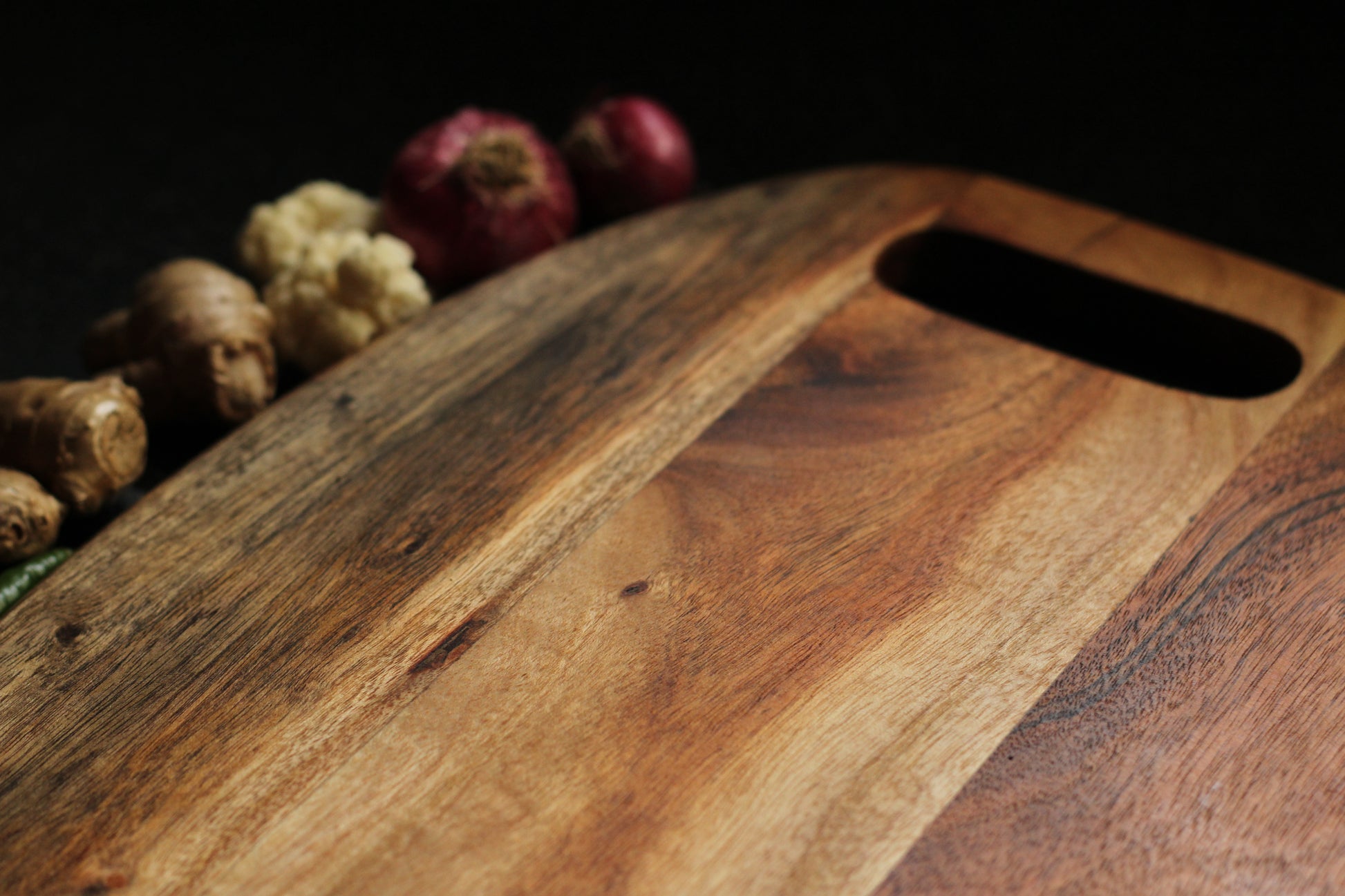 Compact acacia board leaning against a kitchen backsplash, showcasing storage convenience.