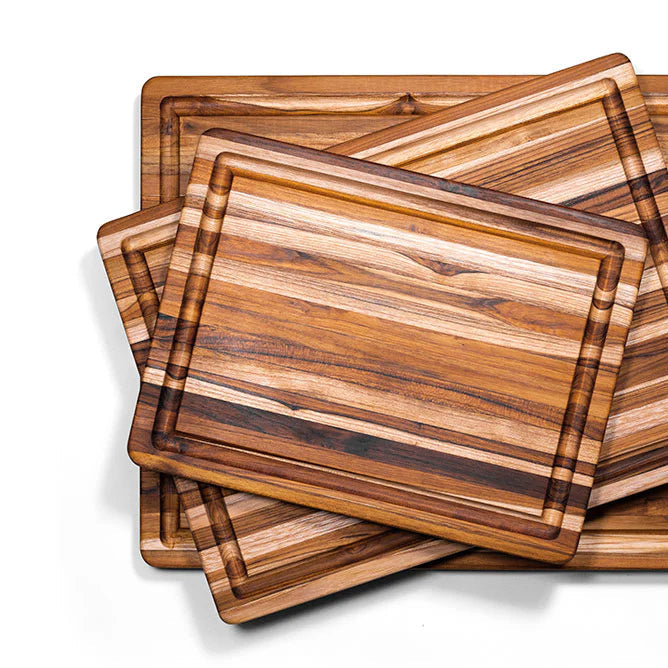 Lifestyle image featuring the teak cutting board as a serving platform for bread, cheese, and fruits.