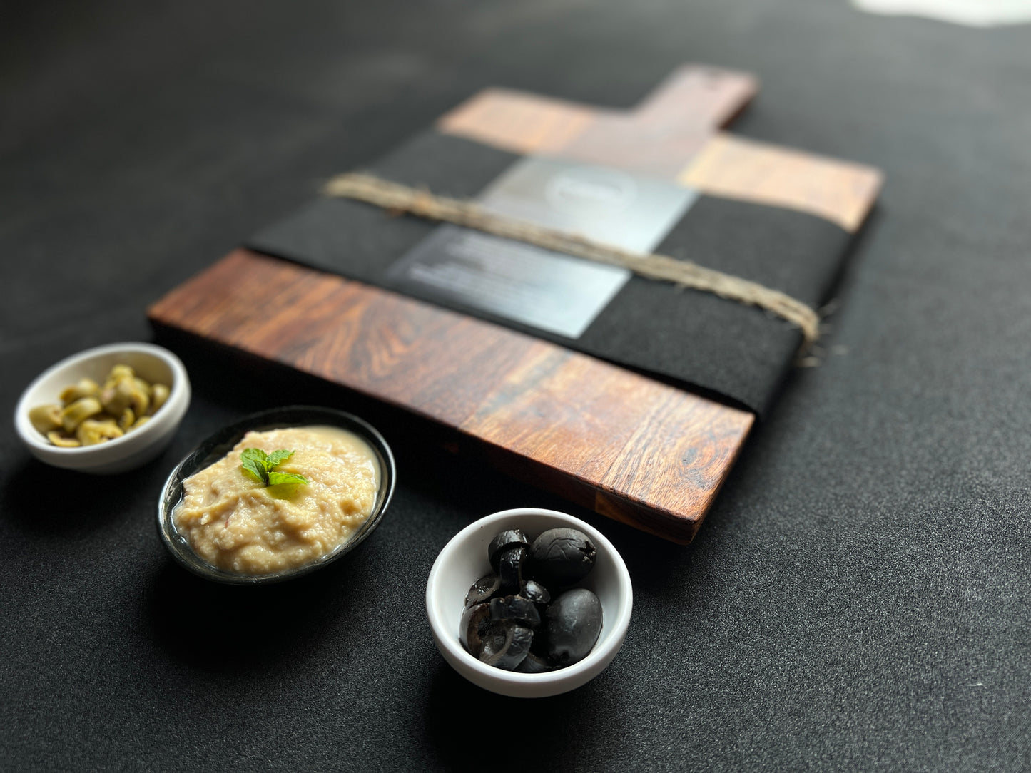 Board styled with cheese, olives, and crackers, showcasing its functionality as a charcuterie board.