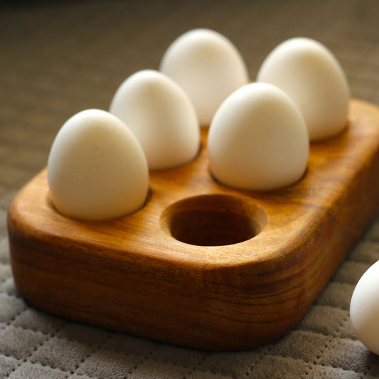 Empty egg tray showing six perfectly carved compartments with a natural matte finish.