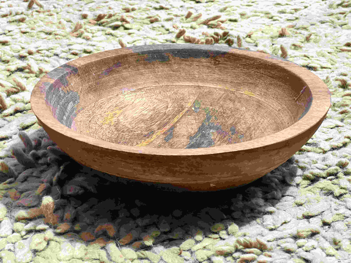 Decorative wooden bowl on a textured surface