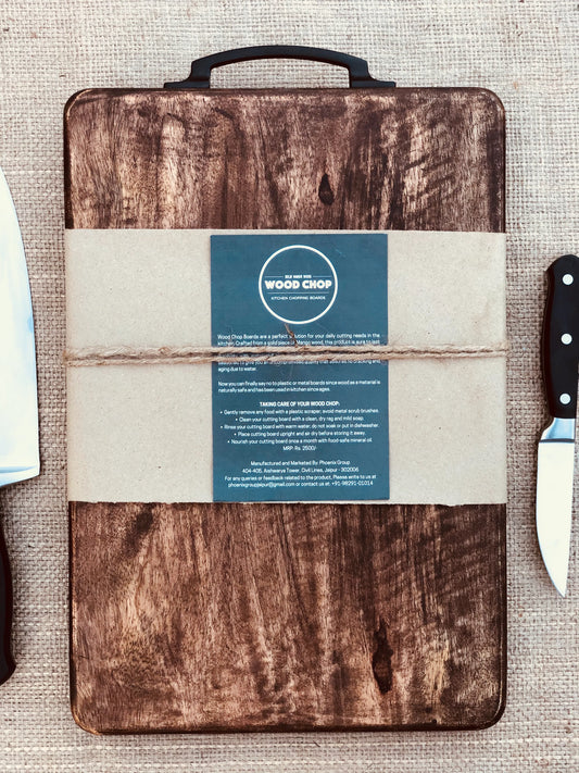 Top view of a dark-finished mango wood chopping board on a kitchen counter.