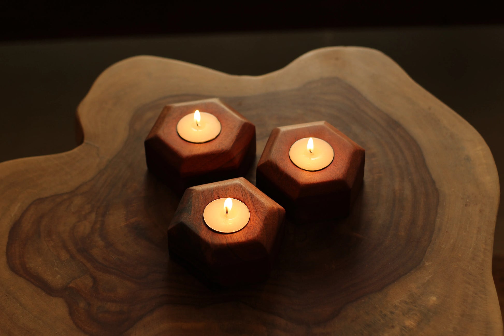 Side profile of all three wooden candle holders stacked to highlight their thickness and polish.