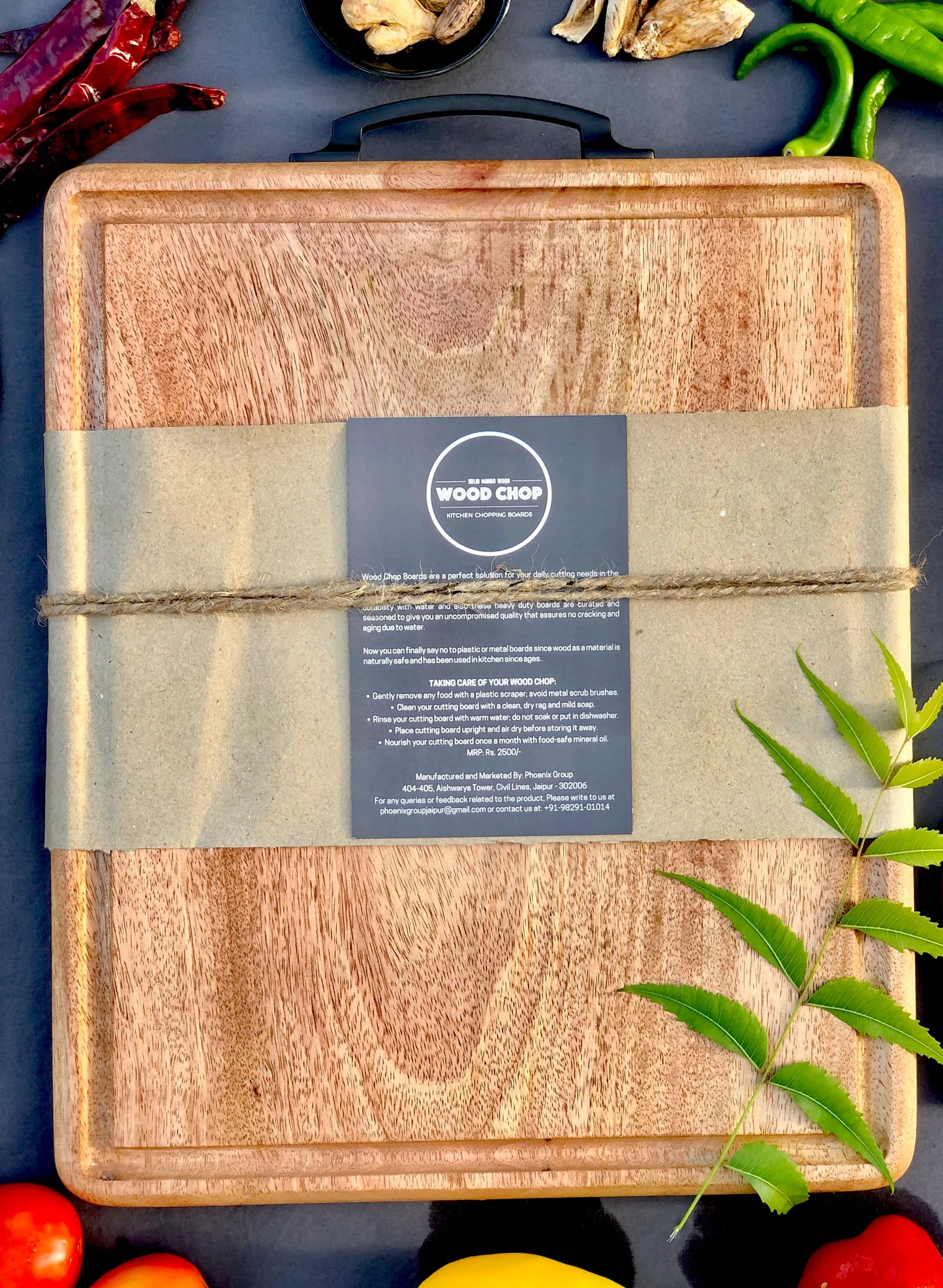 Mango wood cutting board with juice groove, placed on a kitchen island with sliced lemons and a chef’s knife, showcasing durability and elegance.

