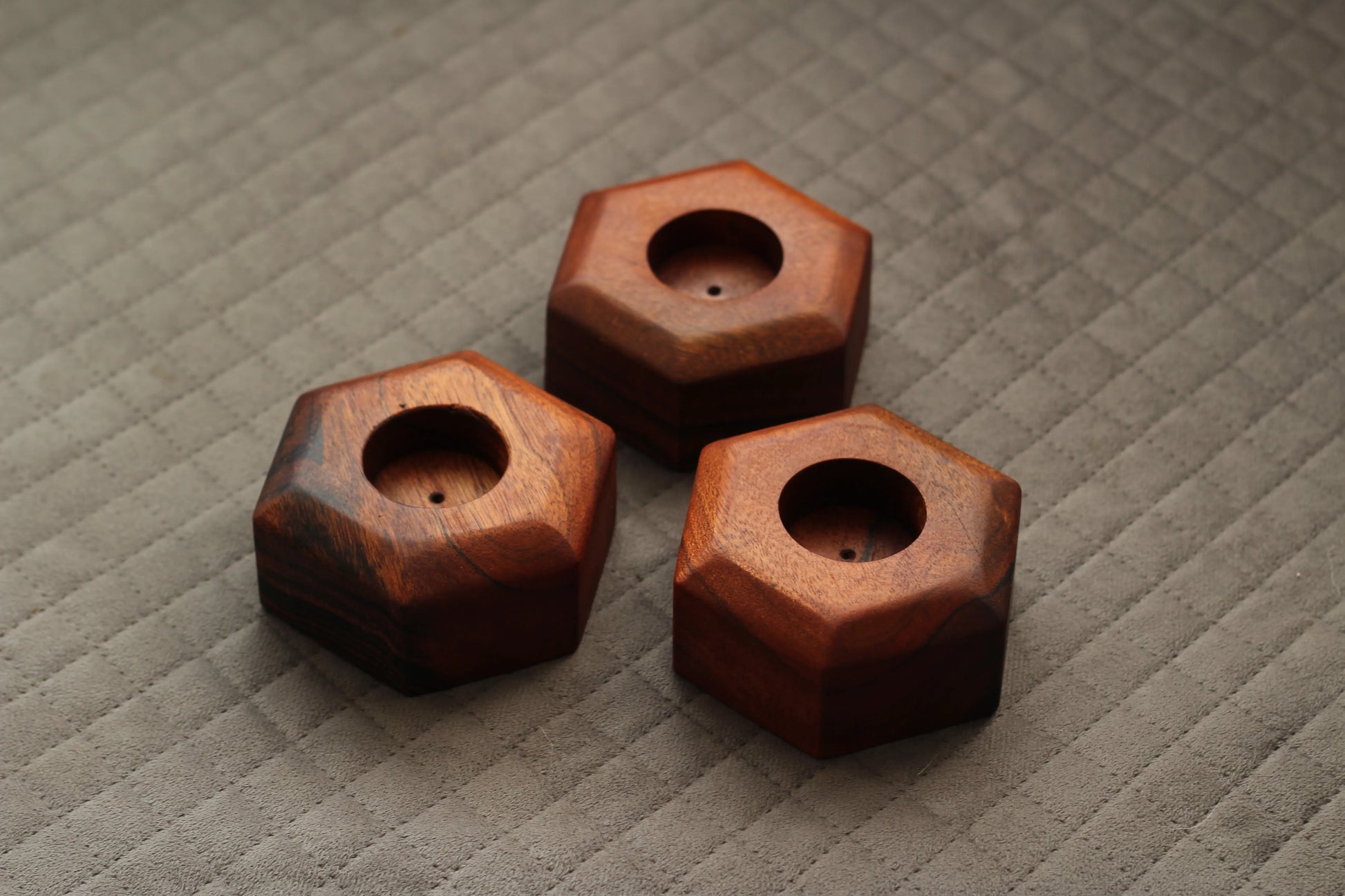 Candle holders placed on a shelf with lit candles, creating a warm and cozy ambiance.

