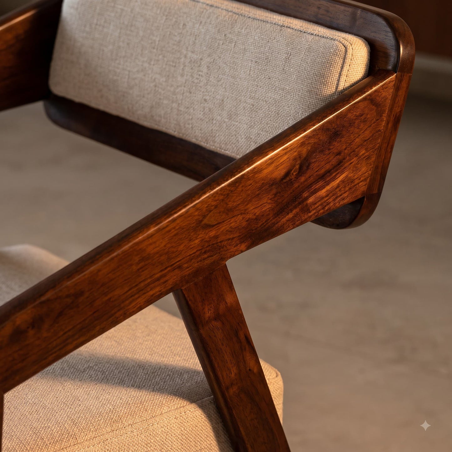 Close-up detail of a wooden armchair with a warm medium-to-dark brown frame and light beige textured fabric cushions.
