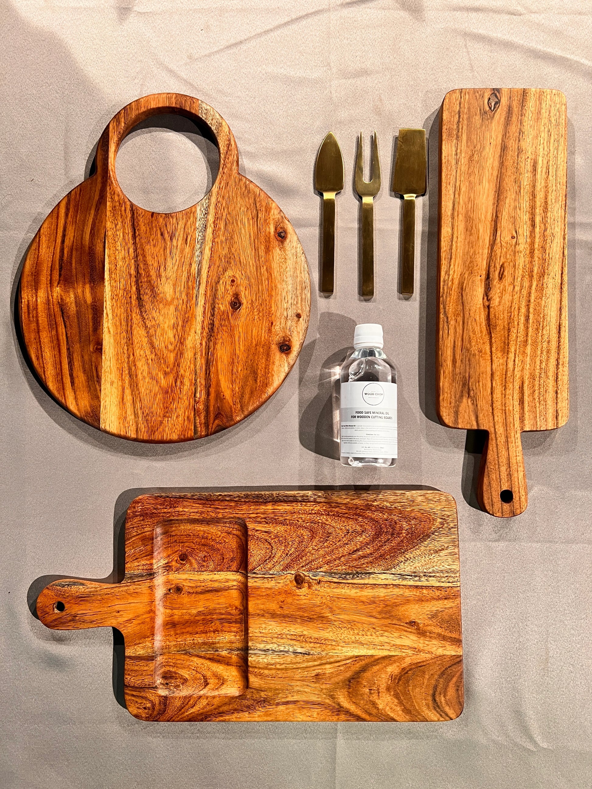 Flat lay of the unpacked set including a serving platter, spoon rest, and coasters arranged on a dining table.