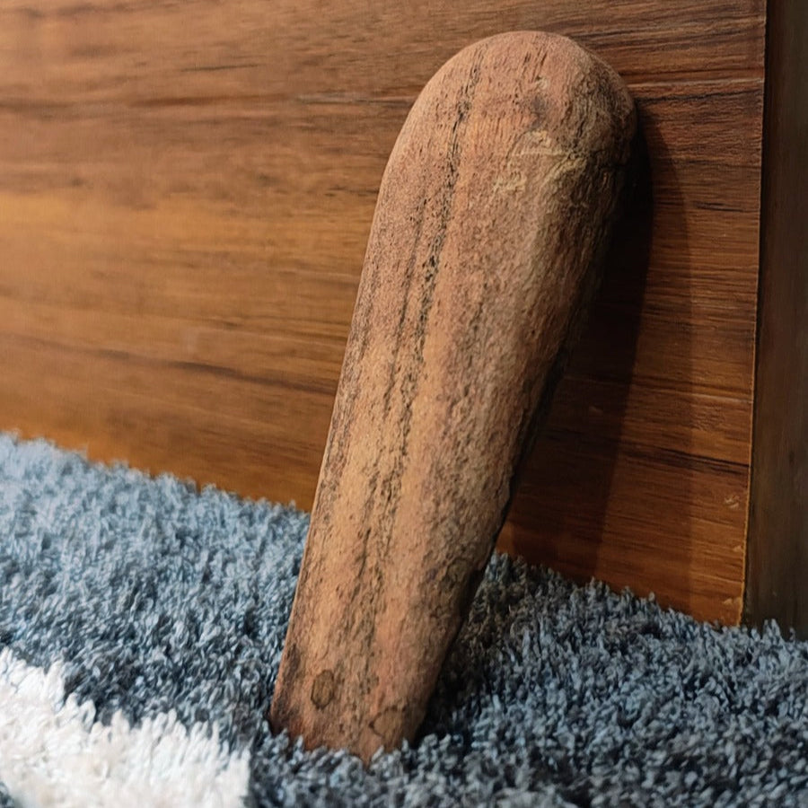 Wooden handle on a wooden surface with a blue textured rug underneath