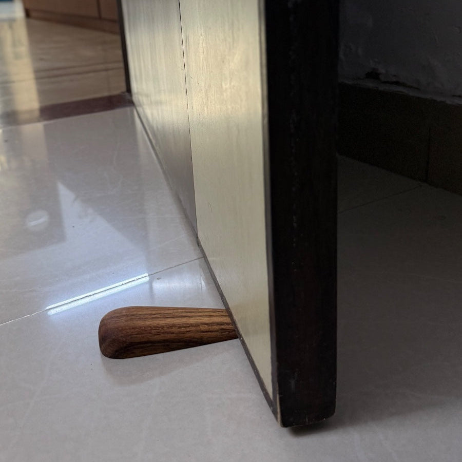 Close-up of a wooden furniture leg on a tiled floor