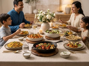 A family of five shares a meal together at a dining table laden with various dishes, set in a warm, beautifully decorated home interior.